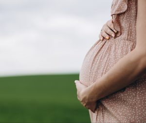 Close up of pregnant belly in nature.
